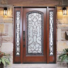 a wooden door with wrought iron designs on the sides and sidelights above it is surrounded by potted plants