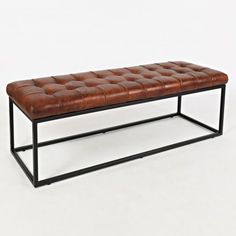 a brown leather bench sitting on top of a metal frame