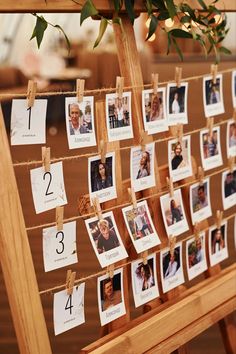 a wooden easel with pictures and numbers pinned to the side, hanging from clothes pins