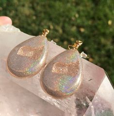 These holographic Teardrop geode earrings made from resin shift from clear gold to a beautiful sparkly rainbow. They are lightweight and won't bother your ears. Please be aware that resin is heat resistant up to 135 degrees. Wearing these earrings in extremely hot temperatures will cause them to be pliable. If this happens, simply place in a cooler location. I am not responsible for any damaged earrings due to extreme heat. Made by Katie Glover Resin Art by Katie 2020 Contact me on my Instagram Sparkling Drop Jewelry For Gifts, Sparkling Drop Jewelry Gift, Sparkling Drop-shaped Jewelry Gift, Teardrop Resin Jewelry, Iridescent Sparkling Jewelry As Gift, Iridescent Sparkling Jewelry Gift, Sparkling Iridescent Jewelry As Gift, Sparkling Iridescent Jewelry For Gifts, Iridescent Drop Earrings For Gift