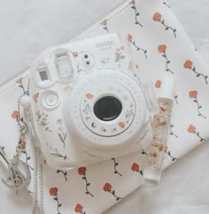 a white camera sitting on top of a table next to a napkin and bottle opener