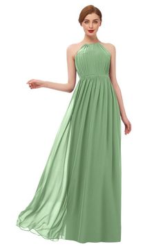 a woman in a long green dress with halt neck and pleaed skirt, posing for the