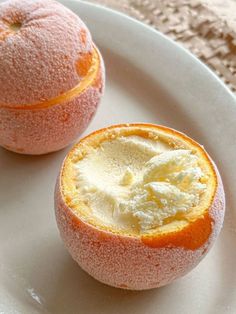 two oranges are sitting on a plate with powdered sugar