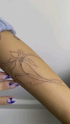 a woman's arm with a flower tattoo on the left side of her arm