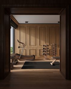 there is a gym with wooden walls and exercise equipment on the floor in front of an open door