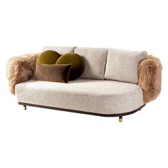 a couch with two pillows on it and some fur around the armrests, sitting against a white background