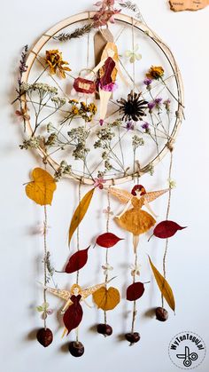 a dream catcher with flowers and leaves hanging from it