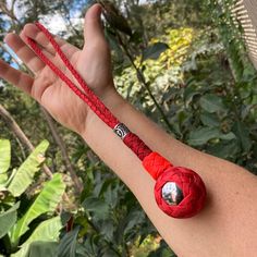 a person's arm with a red string bracelet on it and a silver bead around the wrist