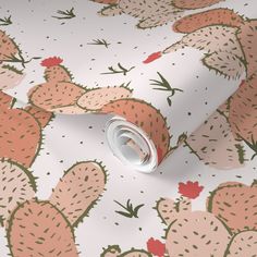 a white wallpaper with pink and green cactus designs on it's side, next to a roll of toilet paper