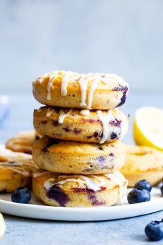 a stack of lemon blueberry muffins with icing on a white plate