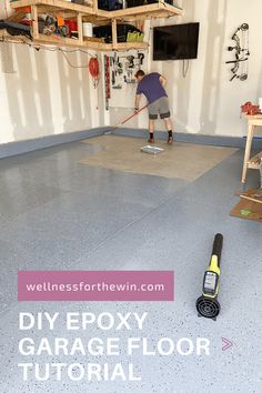 a garage floor is being worked on by a man with a power tool in his hand