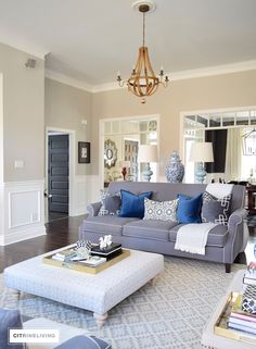 a living room filled with furniture and a chandelier hanging over the top of it