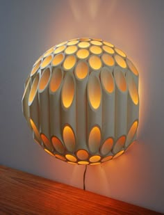 a lamp that is on top of a wooden table next to a wall mounted light