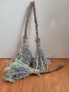 two brooms that are sitting on the floor next to each other and one is made out of twigs