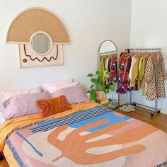 a room with a bed, mirror and clothes rack