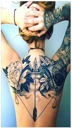 the back of a woman's body with tattoos on it