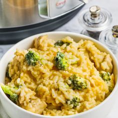 a bowl filled with rice and broccoli next to an electric pressure cooker