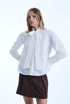 This original James Lakeland design features a cotton shirt adorned with beautiful crochet appliques. The band collar, buttoned cuffs, and button plate all showcase intricate detailing. Cut in a relaxed fit, this button-up shirt provides exceptional comfort due to its slight elasticity. The dramatic tie at the neck can also be styled as a bow or left casually undone.     Made in Italy Fabric 1 98% Cotton, 2% Elastane Fabric 2 50% Cotton, 50% Polyamide. Machine Wash at 30°C, Do not bleach, Perman Fall Cotton Blouse With Lace Collar, Fitted Cotton Tops With Detachable Collar, Fitted Long Sleeve Top With Detachable Collar, Cotton Blouse With Lace Collar For Fall, Classic Fall Blouse With Lace Cuffs, Button-up Top With Lace Collar For Fall, Fall Button-up Tops With Lace Collar, Long Sleeve Cotton Shirt With Lace Trim, Lace Collar Button-up Tops For Fall