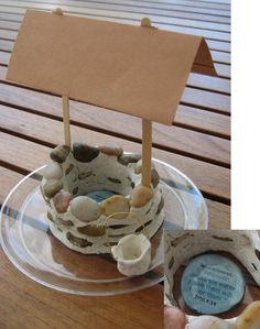 there is a cake with a sign on it and some shells in the shape of a boat