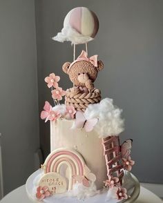 there is a cake decorated with pink and white decorations on it, including a teddy bear