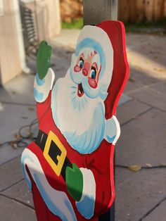 a painted santa clause on the side of a pole