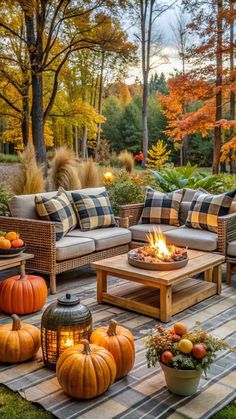 an outdoor patio with pumpkins and candles on the table, surrounded by fall foliage