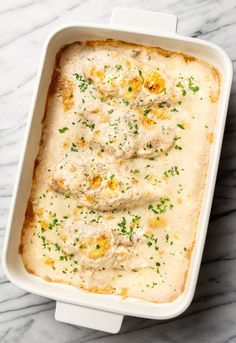 a casserole dish with meat and cheese in it on a marble countertop