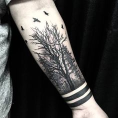 a tree and birds tattoo on the arm