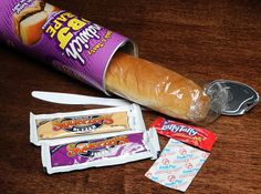 a loaf of bread sitting on top of a wooden table next to some candy bars