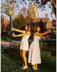 two women in white dresses holding wine bottles