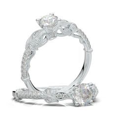 a white gold engagement ring with an intricate design and round brilliant diamonds on the band