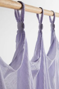 three pieces of cloth hanging from a wooden rod