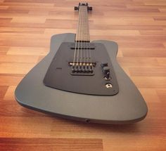 an electric guitar sitting on top of a hard wood floor