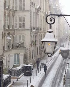 a street light is covered in snow as people walk on the sidewalk