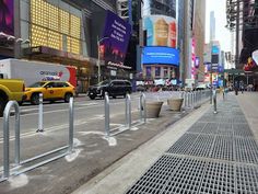 a city street with cars and people walking on the side walk next to tall buildings