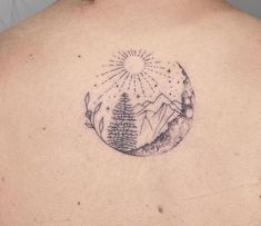 a man with a tattoo on his back that has trees and mountains in the background