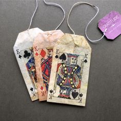 three tags with playing cards attached to them