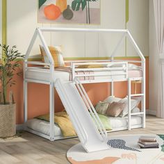 there is a bunk bed with a slide on the bottom and an orange wall behind it