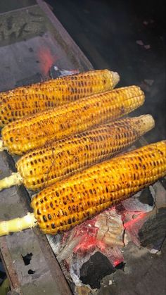 grilled corn on the cob being cooked over an open flame