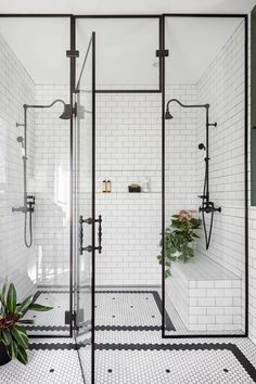 a white tiled bathroom with black and white flooring, shower stall and sink area