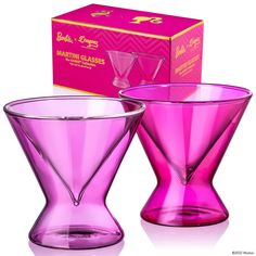 two purple glass vases sitting next to each other in front of a pink box