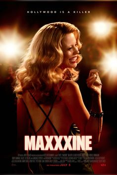 a woman holding a microphone in front of a poster for the movie maxxiine