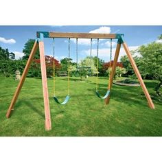 a wooden swing set with swings in the grass