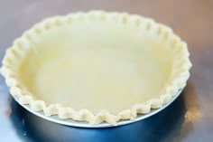 an uncooked pie crust in a metal pan