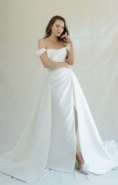 a woman in a white dress posing for the camera