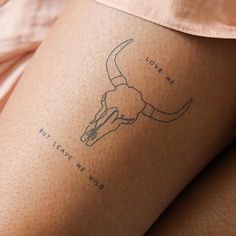 a woman with a tattoo on her leg that has a bull's head drawn on it