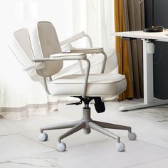 a white office chair sitting in front of a computer desk