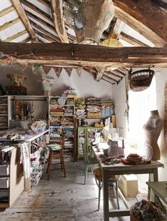 a room filled with lots of clutter and furniture next to a wooden ceiling covered in hanging objects