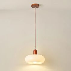 a light fixture hanging from the ceiling in a room with white walls and flooring