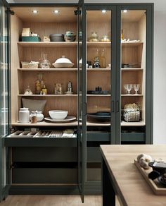 an empty kitchen with wooden shelves and glass doors